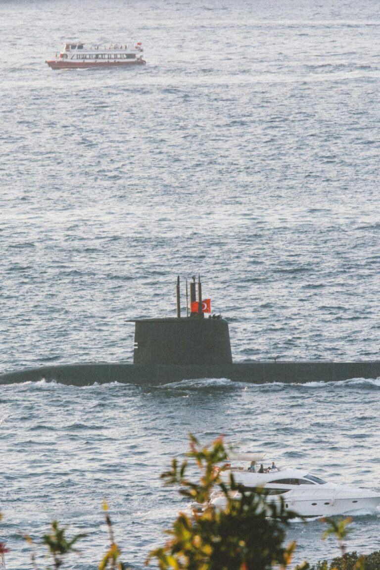 A Turkish Navy submarine navigates the open sea under a clear sky, showcasing maritime military strength.