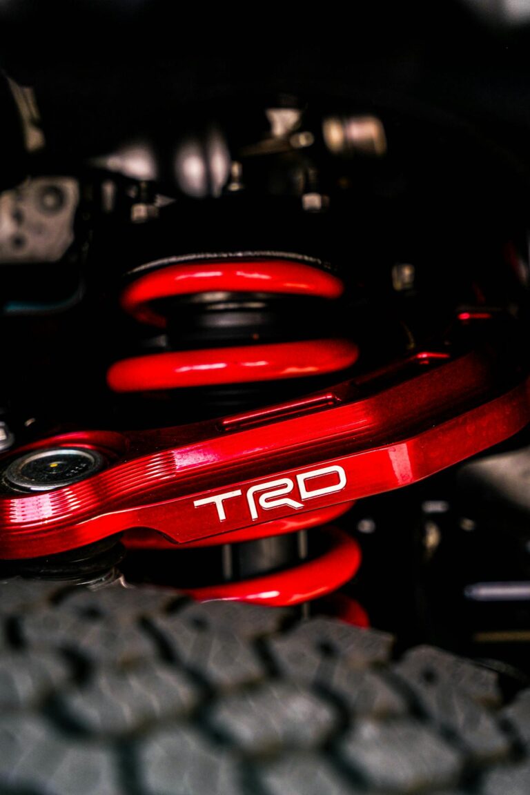 Close-up of a vibrant red TRD suspension system highlighting car engineering details.